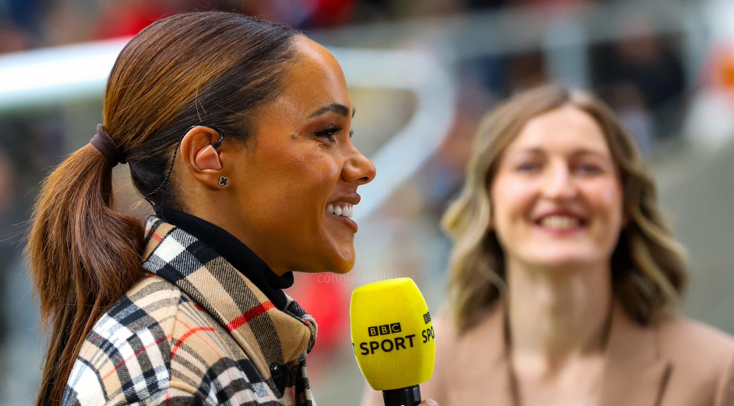 Photo of Alex Scott presenting with Ellen White in the background