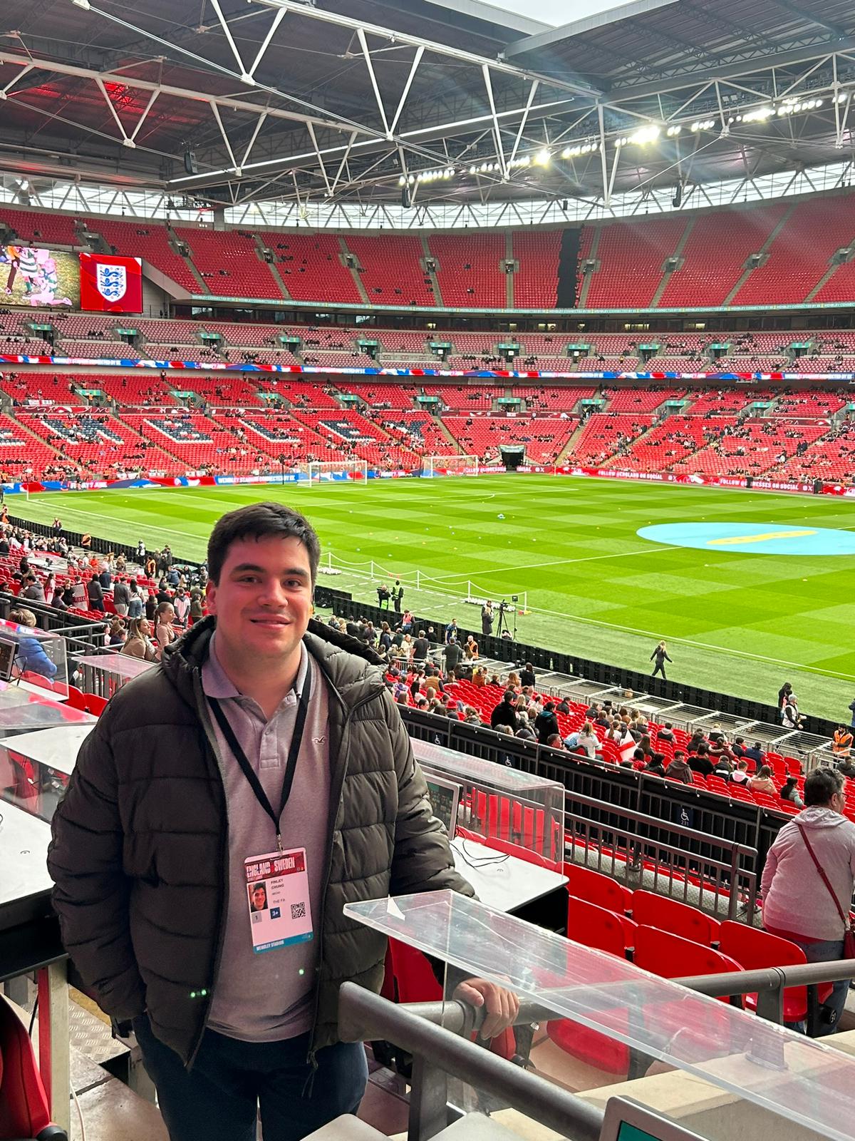 Photo of man with black hair standing at football staium