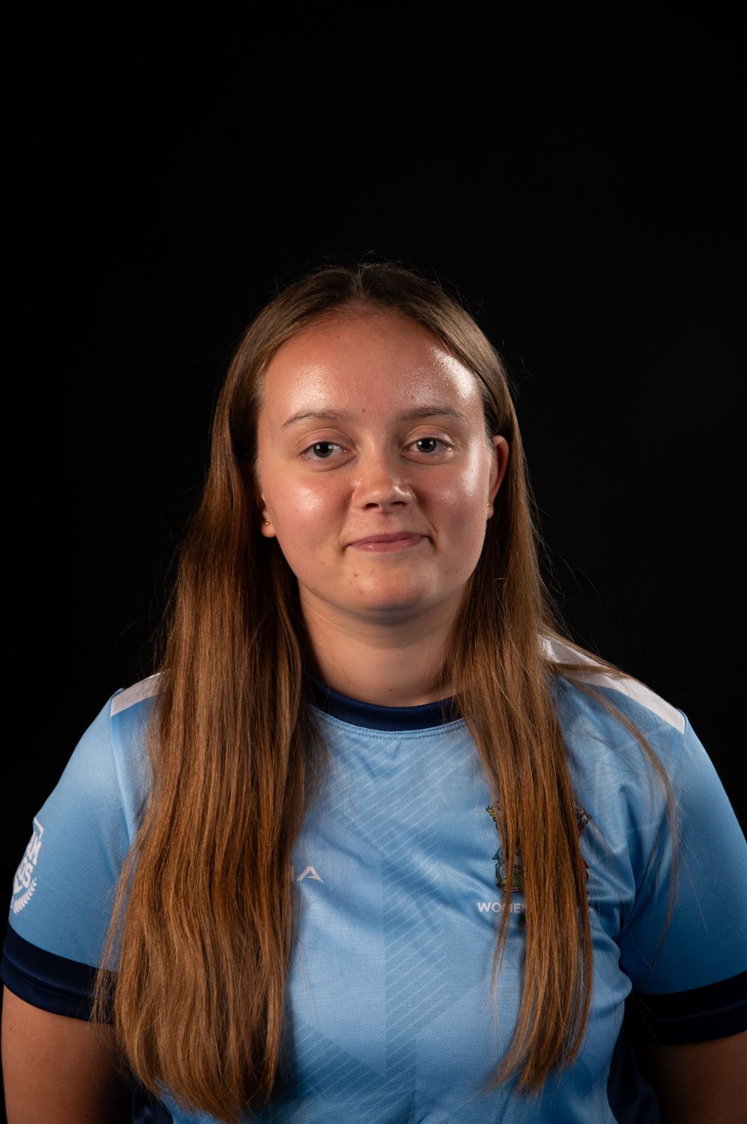 Photo of a white woman with light brown hair in a blue tee shirt
