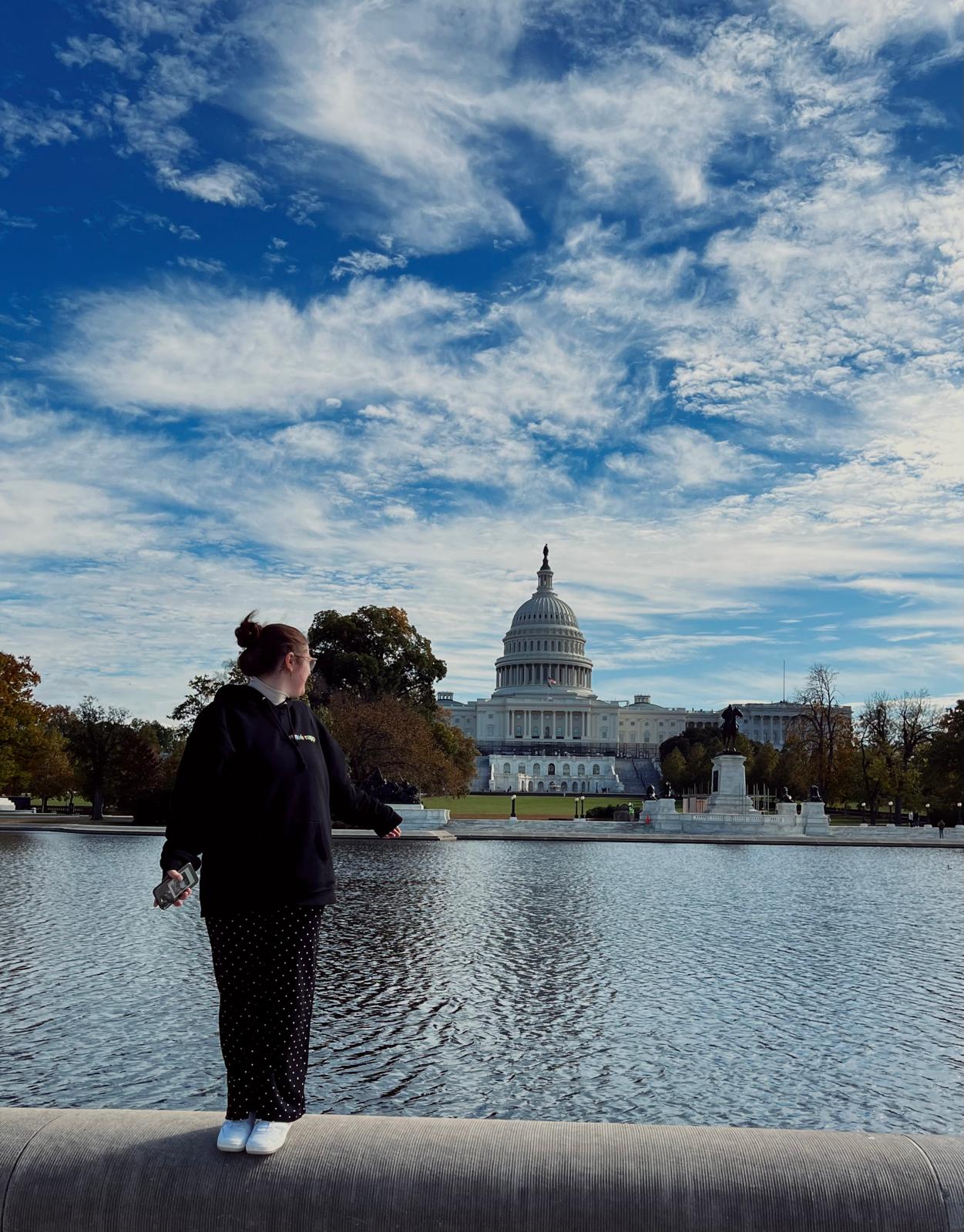 Photo of white woman with her back turned looking at fancy white building