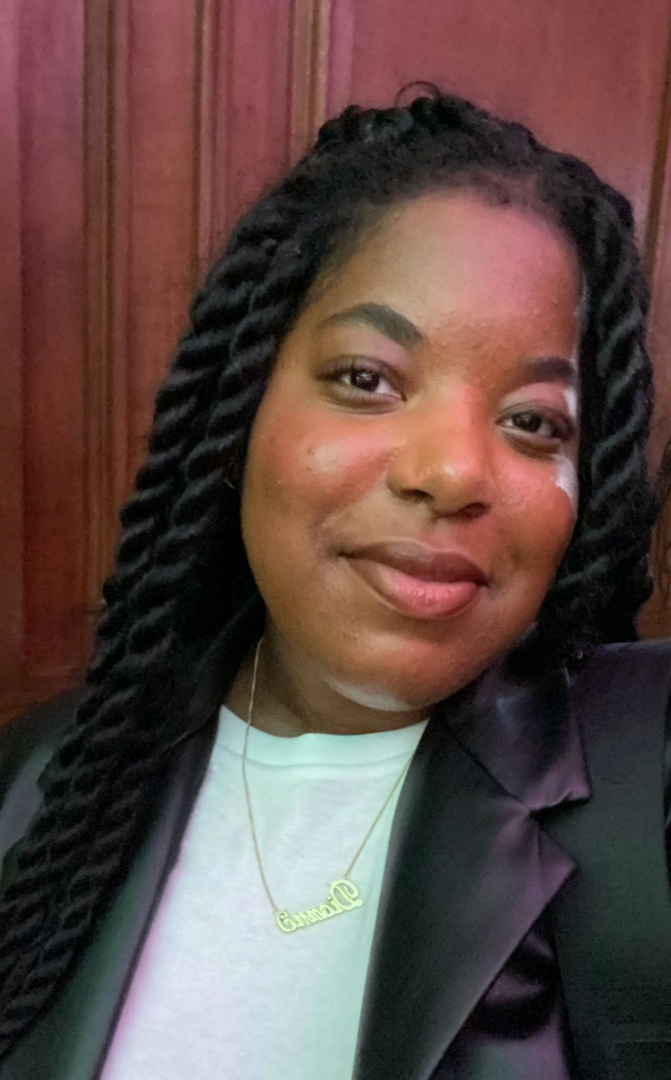Photo of a black woman wearing a white shirt smiling