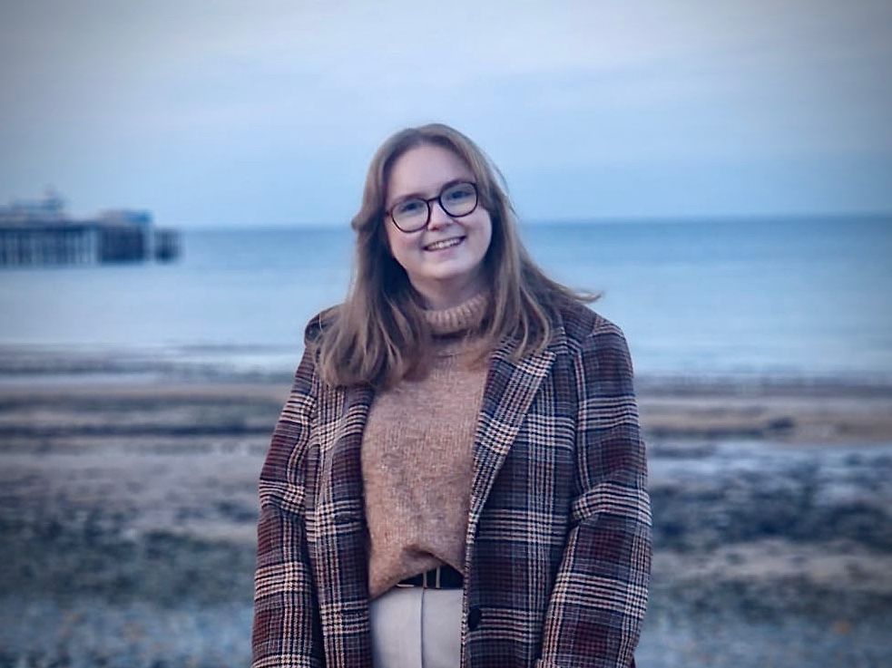 Photo of white woman standing on beach.