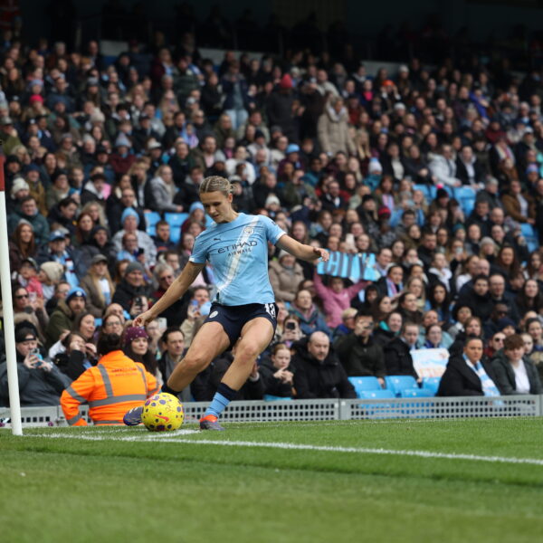 Kerstin Casparij wearing a light blue Man City home shirt taking a corner
