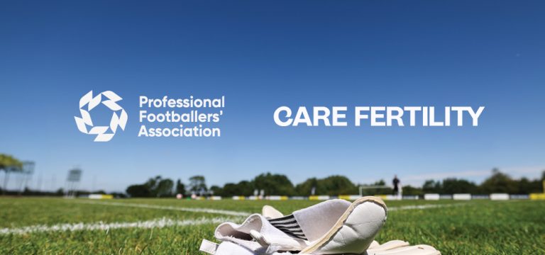 A pair of white football boots rests on the grass beside a football pitch beneath a clear blue sky, with the Professional Footballers' Association and Care Fertility logos displayed prominently above the horizon.