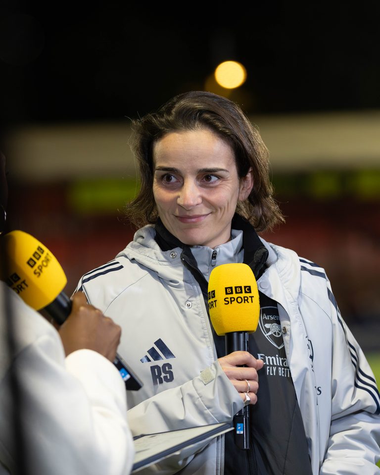 Arsenal Women head coach Renée Slegers speaking into a BBC Sport microphone during a pitchside interview.